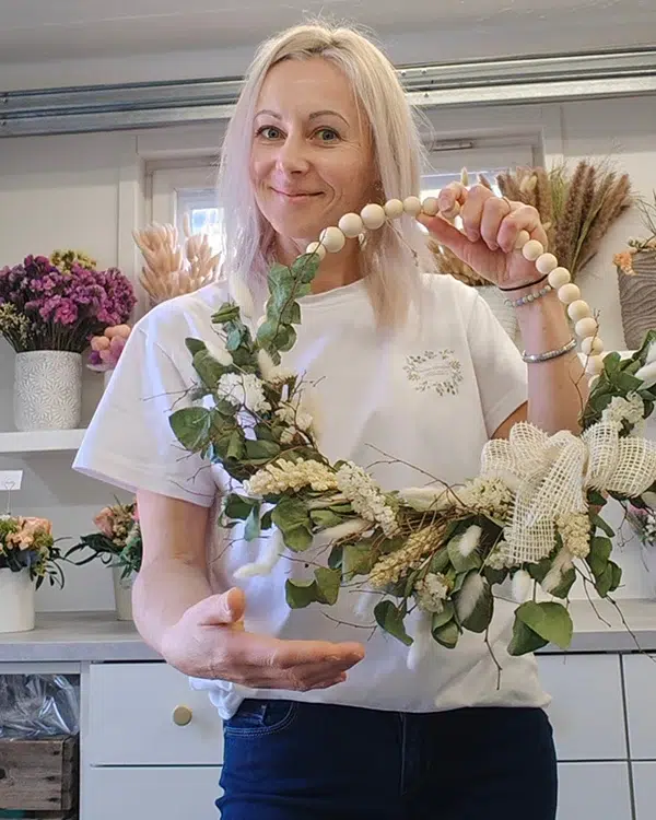 Kranssi kukista esittelemassa merily kukkakauppias
